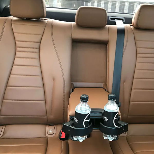 Blick auf die hellbraune Lederrückbank einer Chauffeurlimousine mit zwei Getränken in Getränkehaltern.