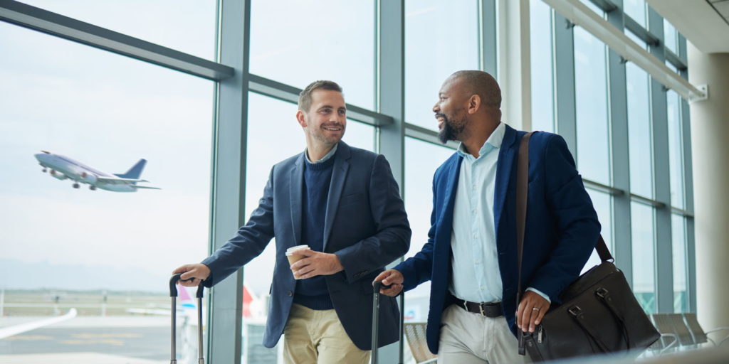 Zwei Männer in einem Flughafengebäude auf dem Weg zur Abholung durch einen Limousinenservice.